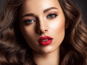 Beautiful face of young woman with red lipstick