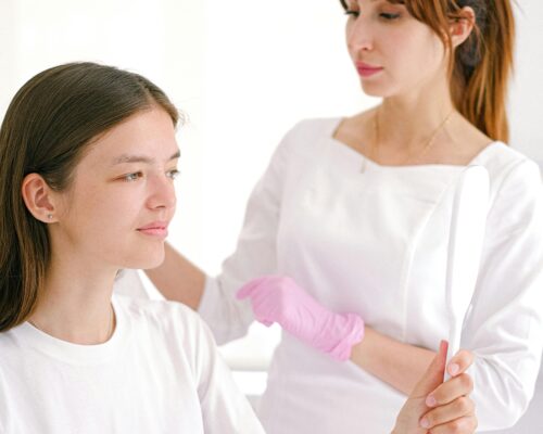 young woman looking at mirror after Deep Plane Facelift Recovery